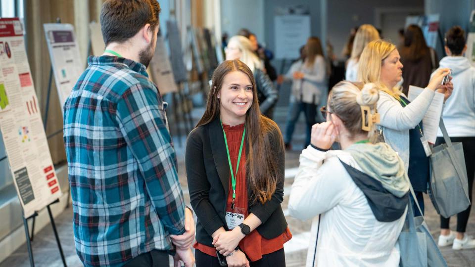 Conference attendees network and review posters